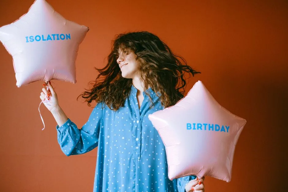 Woman in a blue dress celebrates isolation birthday with star-shaped balloons.