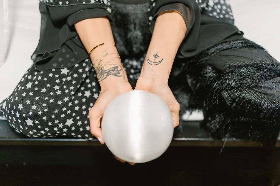 Close-up of a woman with starry attire holding a crystal ball, embracing mystical energies.
